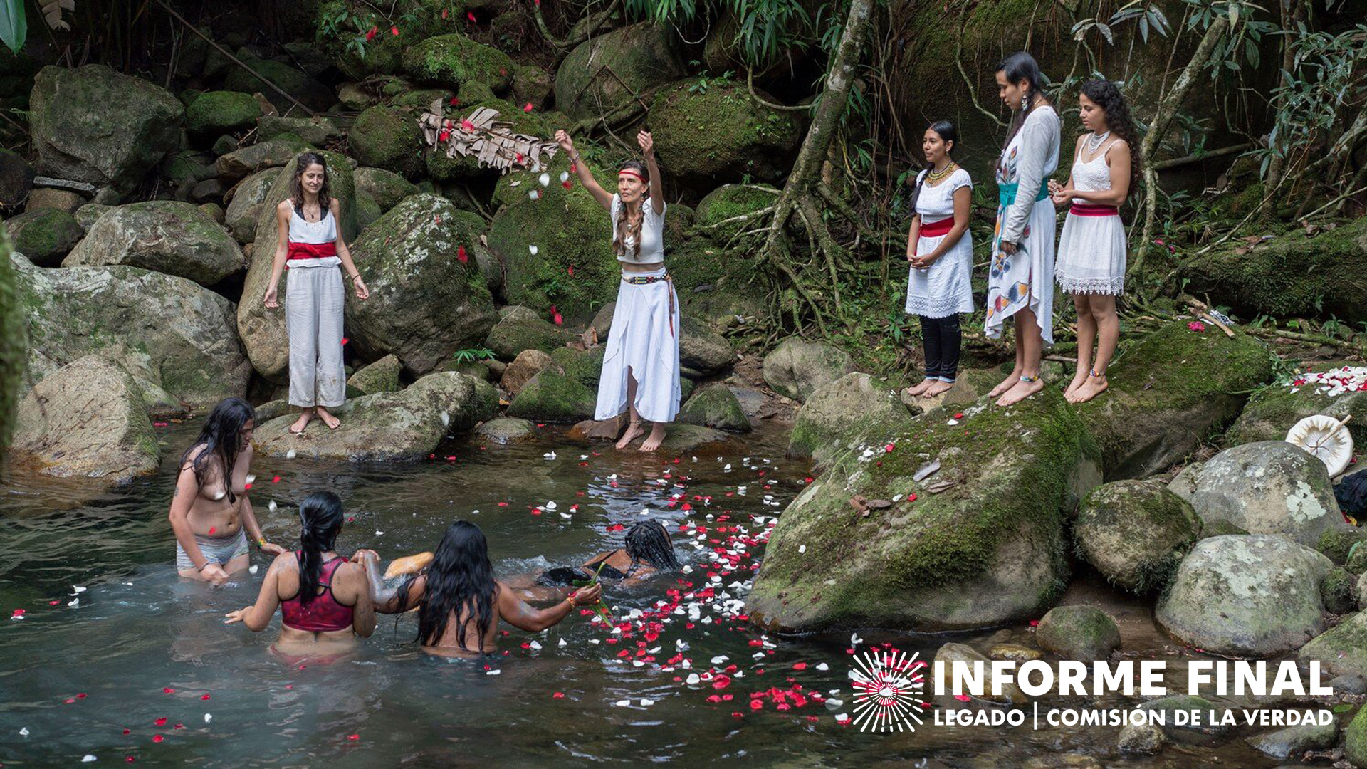 Círculo de mujeres en un río lanzando pétalos de flores 