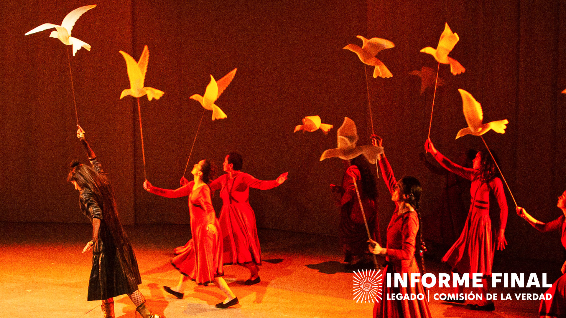 Obra de teatro, mujeres levantando varas con figuras de pájaros en la punta