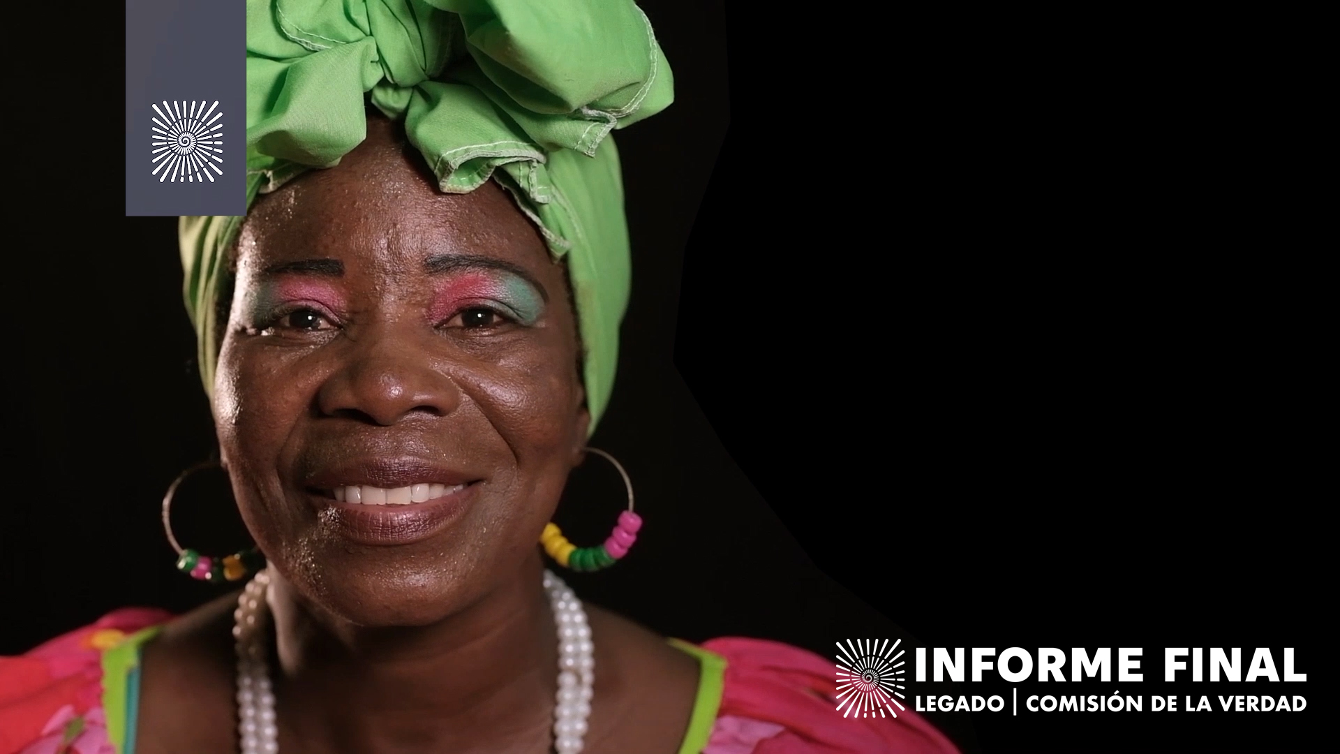 Mujer afro sonriente con turbante verde.