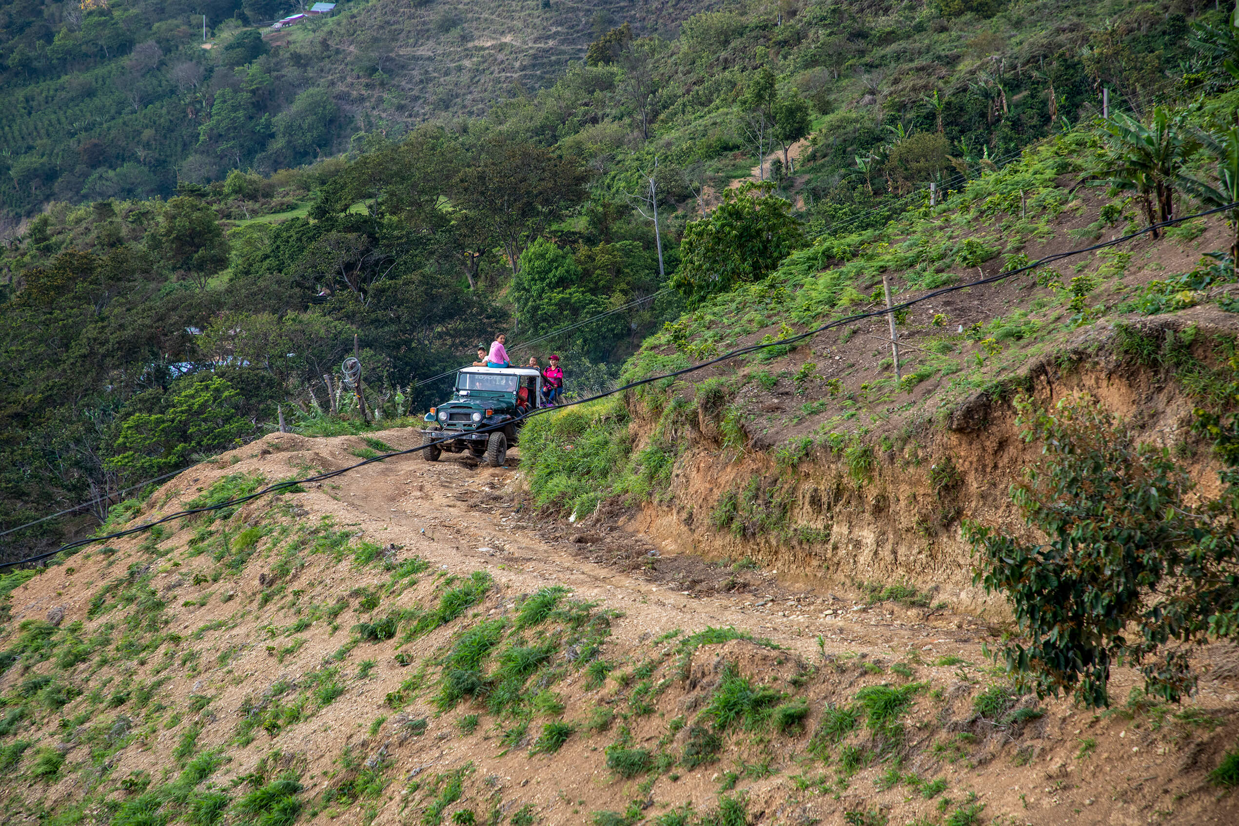 En un campero sin carpa, un grupo de personas sube por las montañas de la Serranía del Perijá.