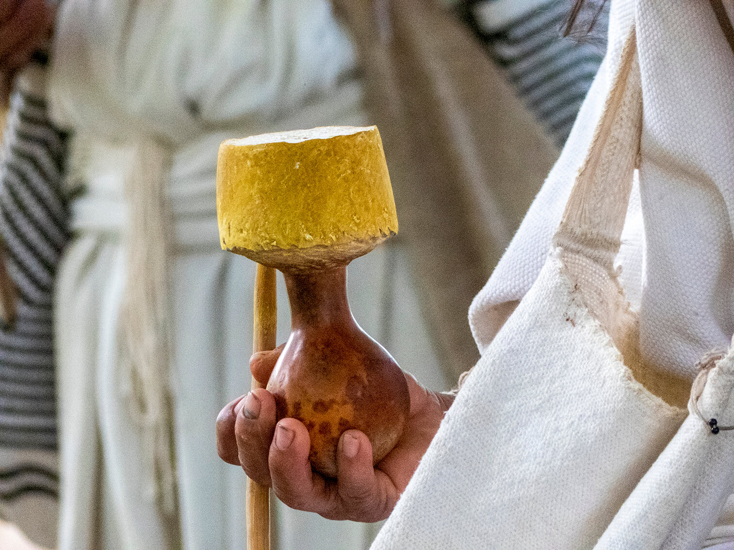 Un hombre arhuaco sostiene el calabazo de un poporo en su mano derecha y entre sus dedos lleva el madero con el que mambea.
