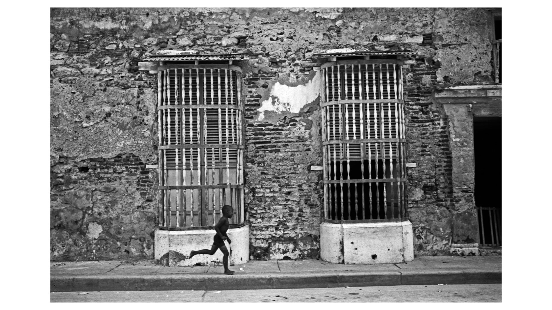 Niño corriendo por calle de Cartagena 1976 en grises