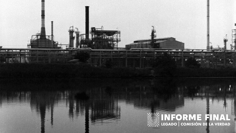 Fotografía antigua en blanco y negro de infraestructura y una construcción cercanas a una ribera