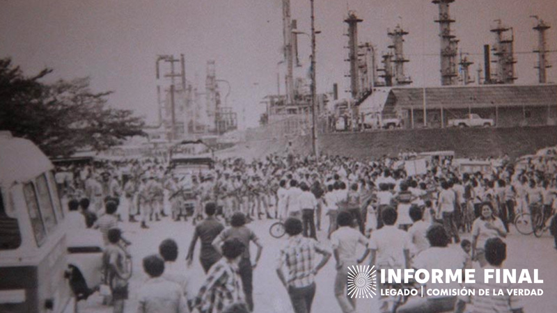 fotografía antigua en blanco y negro de gran número de personas cercanas a estructuras petroleras