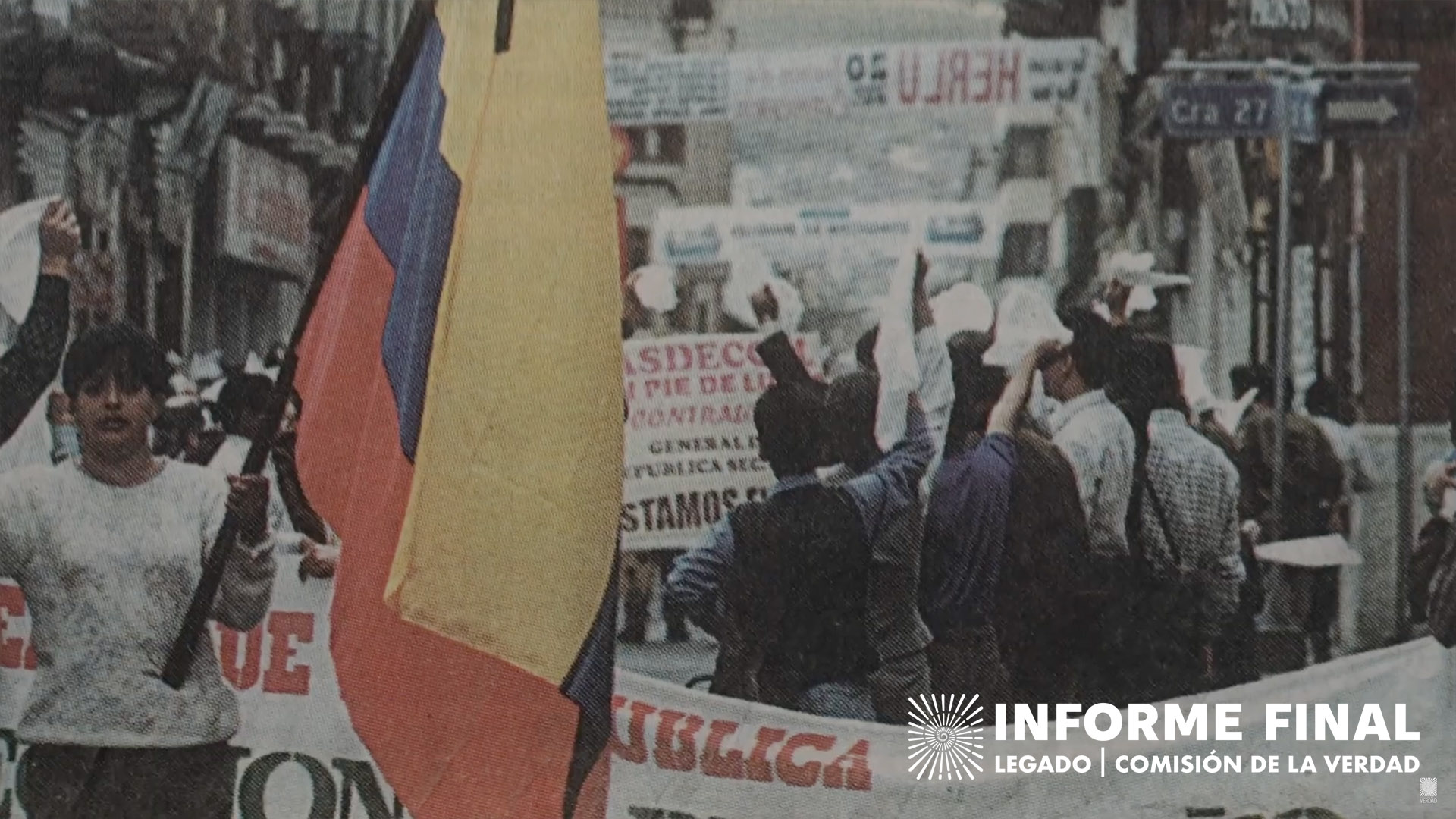 Fotografía antigua de una manifestación, mujer sostiene bandera de Colombia.