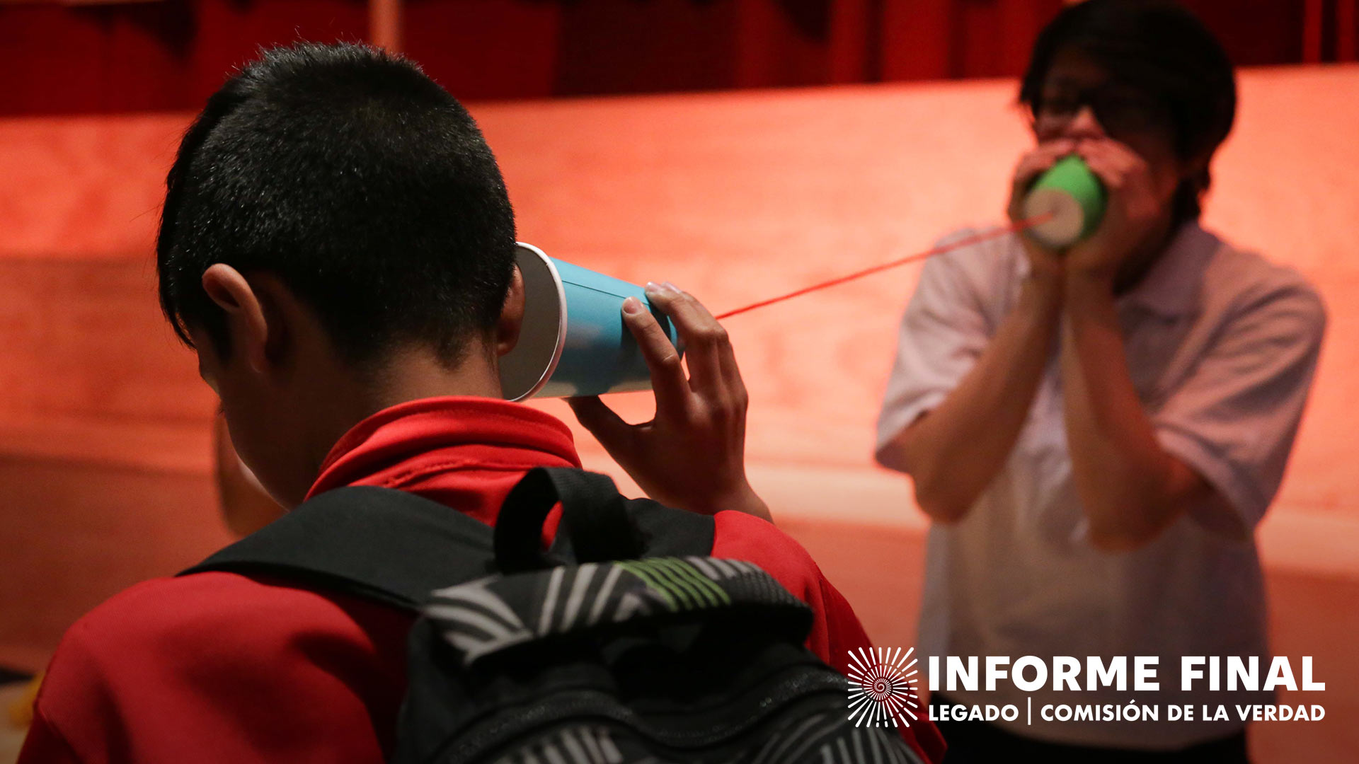 Niños hablando por medio de un teléfono hecho con vasos de plástico