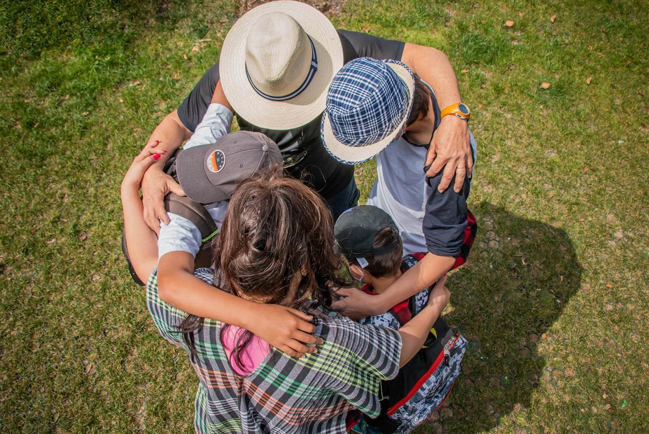 vista aérea. Mujer, tres niños y un hombre se abrazan en círculo