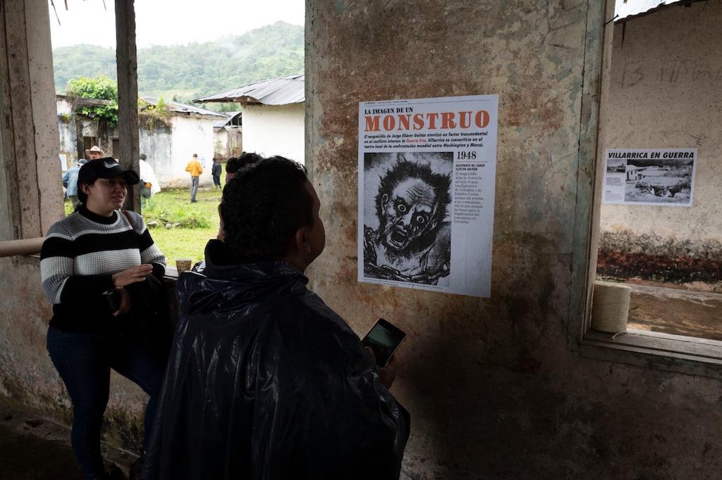 Personas observan un afiche pegado al muro de una edificación abandonada. Texto: La imagen de monstruo 1948