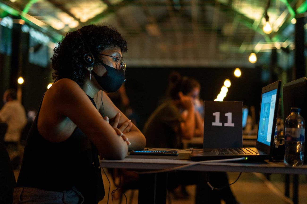 Mesa once, mujer con audífonos participa en videoconferencia