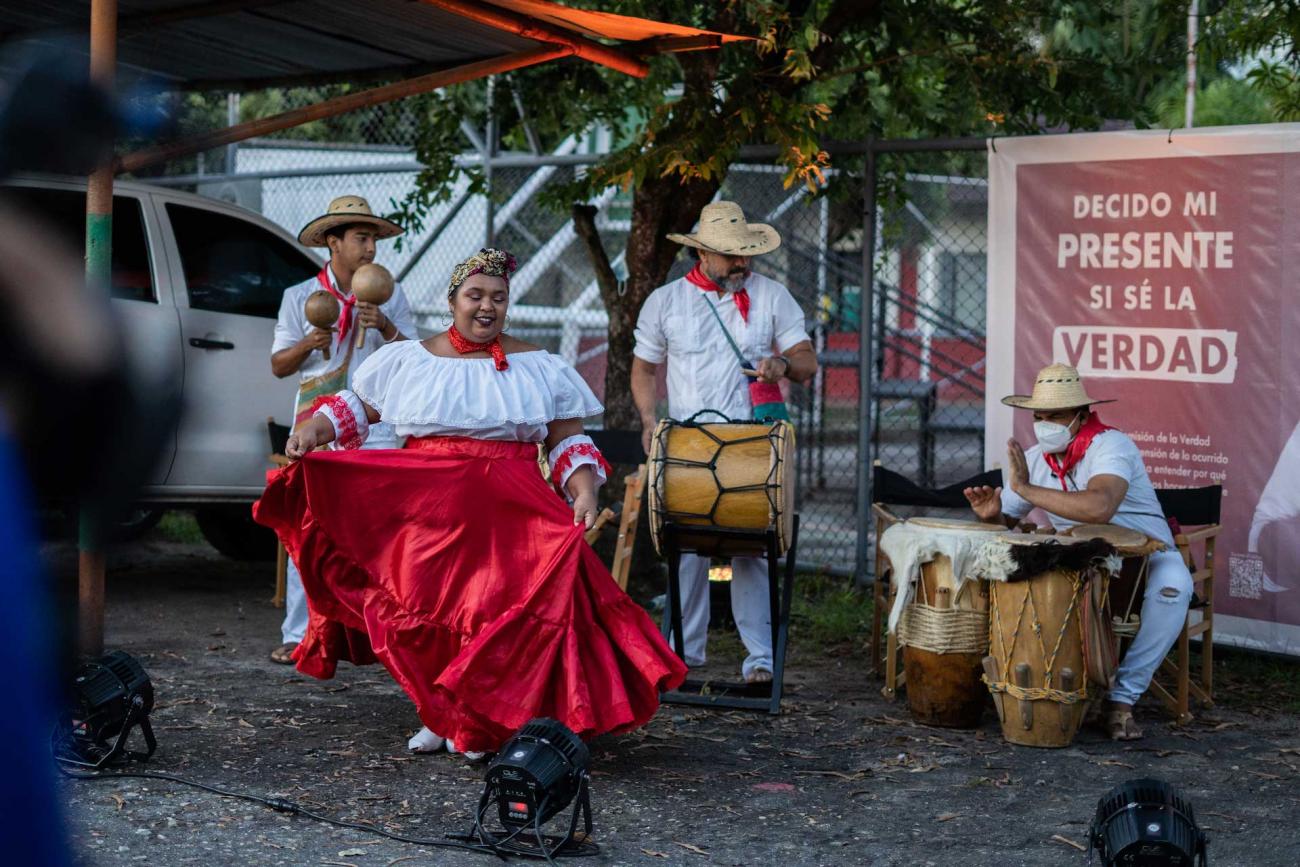 Grupo músical con traje folclórico blanco y pañuelos rojos. Tambora y maracas