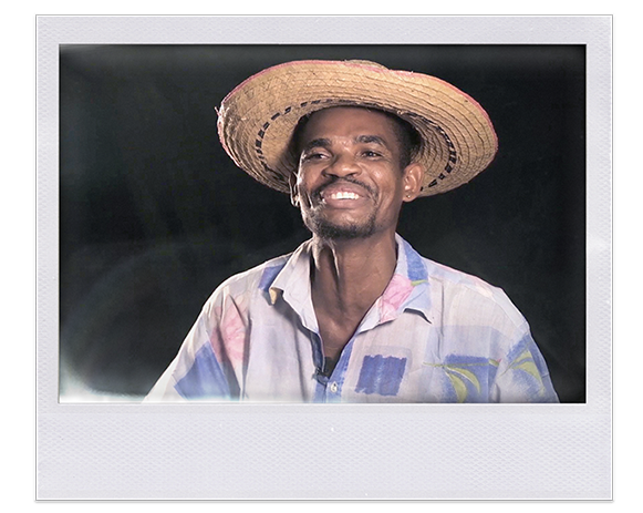 Instantánea. Hombre afro sonriente lleva puesto un sombrero