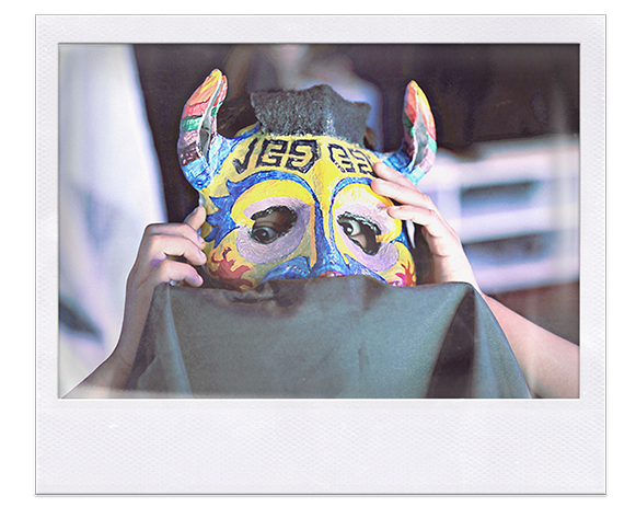 Instantánea. Niño sosteniendo máscara con cachos de toro multicolor