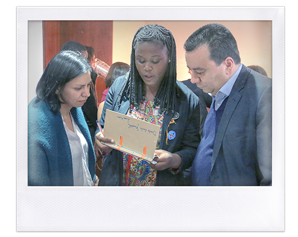 Instantánea. Comisionada Patricia Tobón y dos personas observan un libro hecho a mano