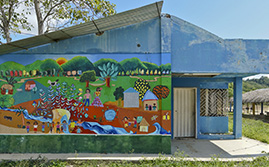 Mural pintado por habitantes de Pichilín, donde hay un paisaje colorido con plantas, animales y personas sonriendo